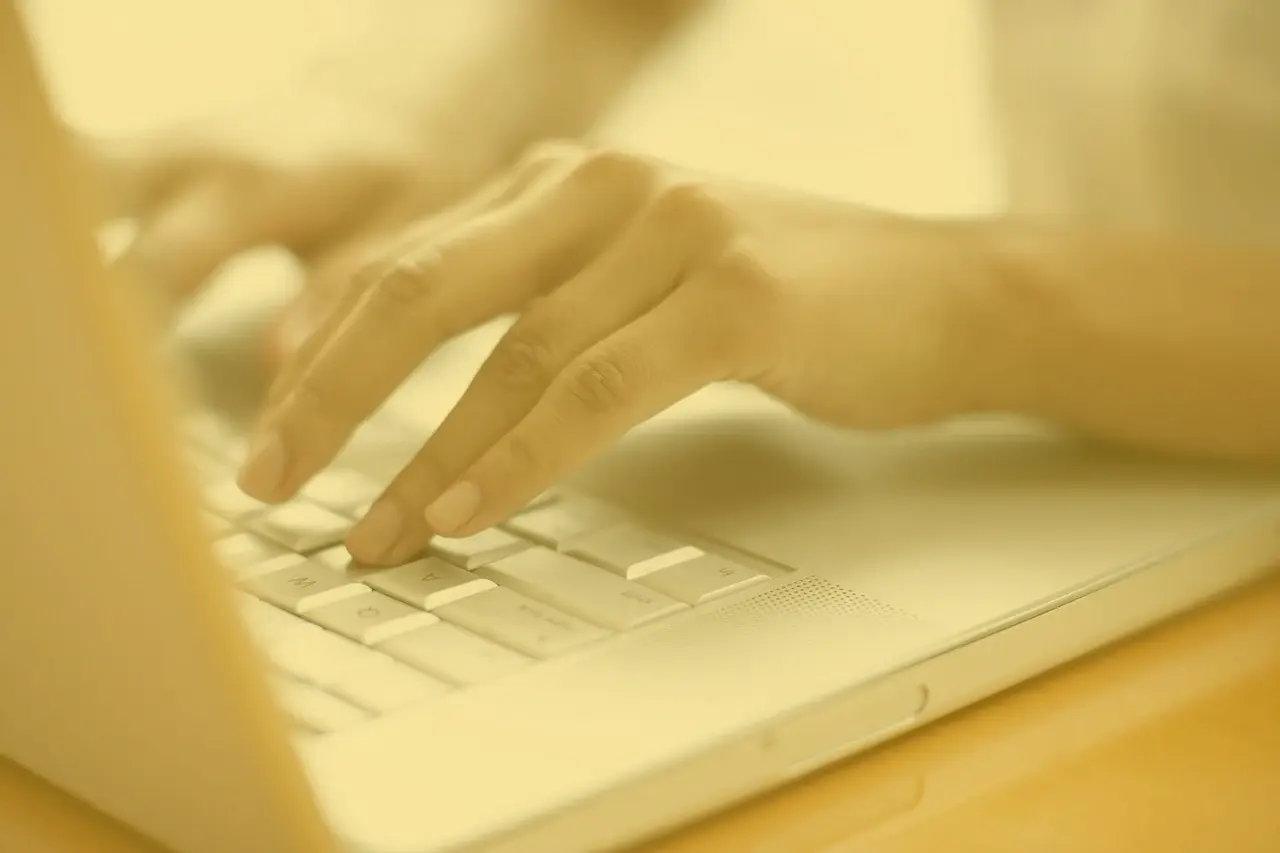 Hände tippen auf Laptop